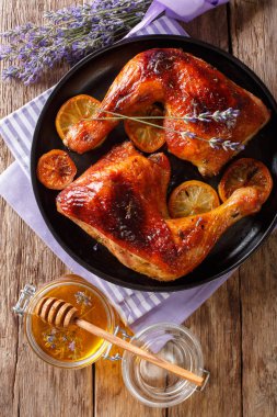 Lavanta bal ve limon yakın çekim bir plaka üzerinde bir tablo ile pişmiş tavuk budu. Abov gelen dikey üstten görünüm