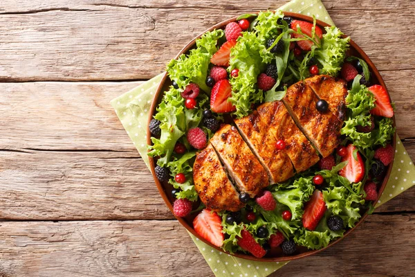 Organik salata Izgara tavuk göğsü ile taze çilek, marul ve roka closeup masada plaka üzerinde. abov üzerinden yatay üstten görünüm