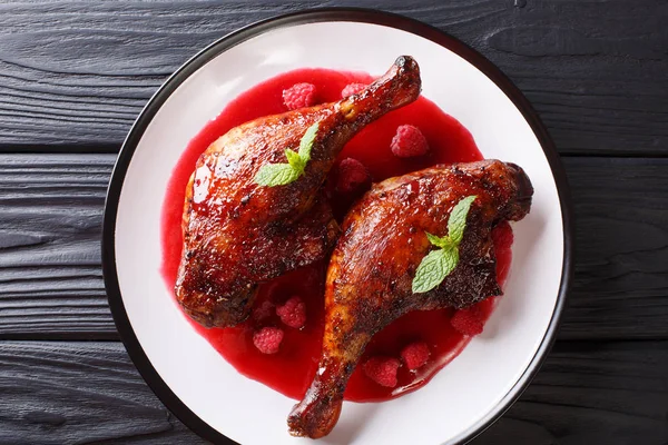 Organik gıda: kızarmış taze frambuaz sos ve nane masada bir tabakta ördek bacaklar. Abov üzerinden yatay üstten görünüm