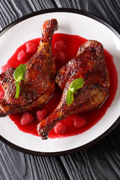 Nane closeup masaya bir tabak kızarmış ördek bacak frambuaz sos ile süslenmiş. Vertica