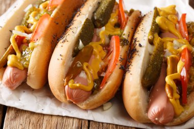 Chicago stil sıcak köpek hardal, domates, salatalık turşusu, soğan ve masanın üzerine sos yakın çekim. Horizonta