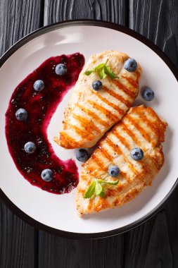 Taze pişmiş ızgara tavuk göğsü bir plaka üzerinde berry sos ve nane closeup ile. Abov gelen dikey üstten görünüm