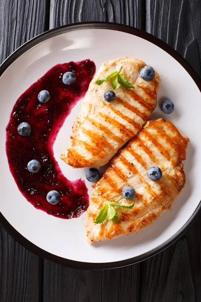 Taze pişmiş ızgara tavuk göğsü bir plaka üzerinde berry sos ve nane closeup ile. Abov gelen dikey üstten görünüm