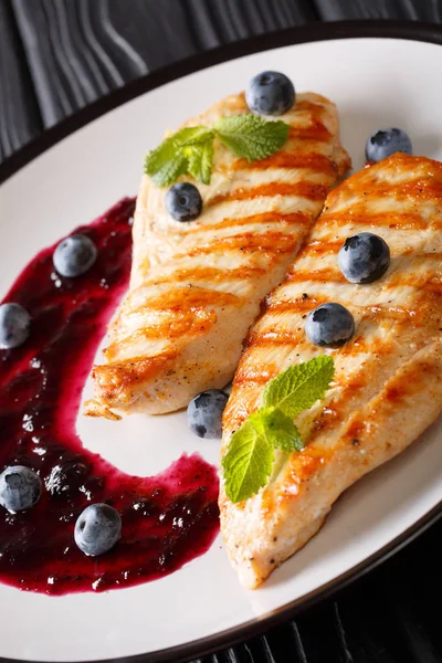 Bir plaka üzerinde yaban mersini sosu ve nane closeup ile ızgara tavuk fileto. Vertica