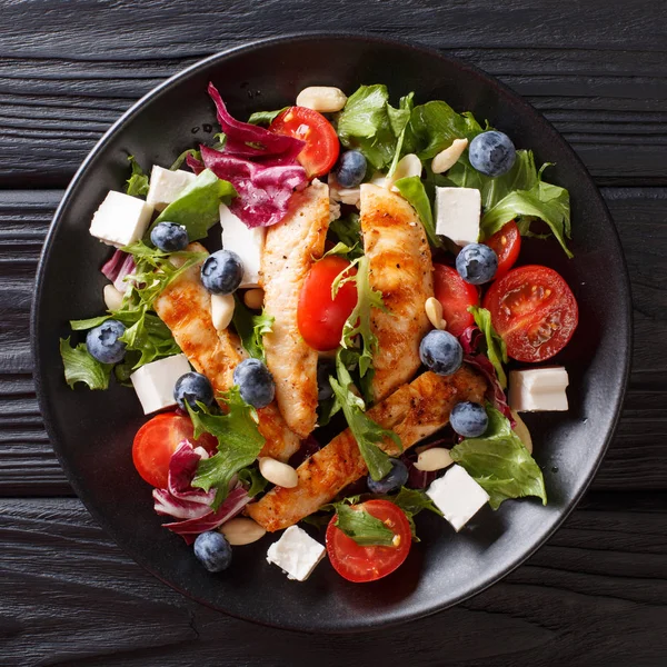 Yaban mersini, beyaz peynir, tavuk, fındık, domates ve marul yakın bir plaka üzerinde çekim ile diyet çerez salata. abov üzerinden üstten görünüm