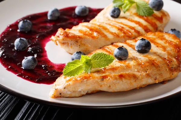 Izgara tavuk göğsü berry yaban mersini sosu yakın bir plaka üzerinde çekim ile. Horizonta