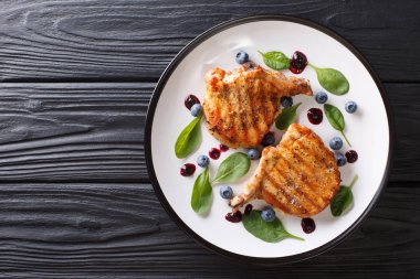 Yaban mersini sosu ve ıspanak yakın çekim ile ızgara domuz biftek. Ho