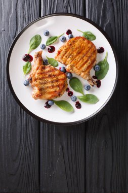 Yaban mersini sosu ve ıspanak yakın çekim bir plaka üzerinde ızgara domuz biftek. Abov gelen dikey üstten görünüm