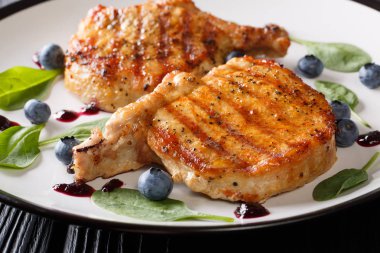 Yaban mersini sosu ve ıspanak yakın çekim ile ızgara domuz biftek. Ho