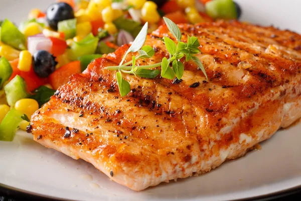 Mısır, yaban mersini ve biber makro bir plaka üzerinde salsa ile ızgara somon fileto. Horizonta