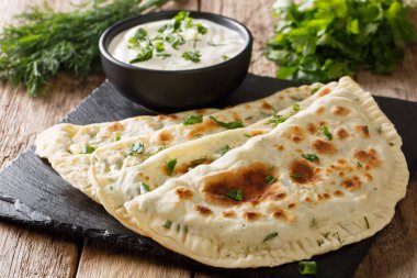 Otlar ile doldurulmuş lezzetli organik düz ekmek qutab masanın üzerine yoğurt yakın çekim ile devam eder. Azeri mutfağı. Horizonta