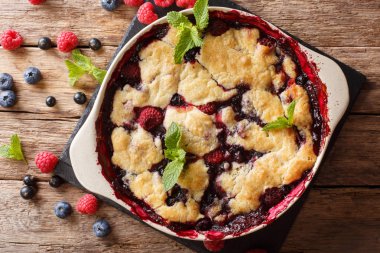 Pasta tatlı tart, ahududu, kuş üzümü ve yaban mersini yakın çekim bir masada pişirme için bir tabak içinde. Abov üzerinden yatay üstten görünüm