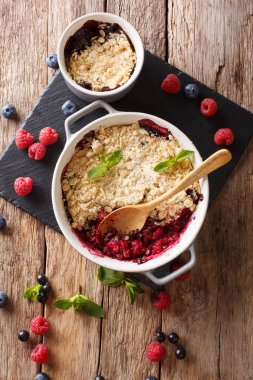 Berry kek kuş üzümü, ahududu ve nane ile dekore edilmiş yaban mersini ile masaya kapatın. Abov gelen dikey üstten görünüm