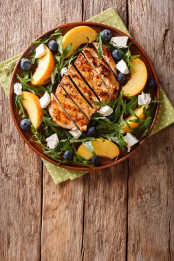 Fitness organik salata Izgara tavuk göğsü ile şeftali, yaban mersini, bir plaka üzerinde bir tablo rukkola ve peynir yakın çekim üzerinden. Abov gelen dikey üstten görünüm