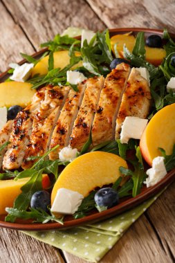 Izgara tavuk, şeftali, yaban mersini, bir tablo bir tabağa roka ve peynir yakın çekim yaz salatası. Vertica