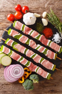 Barbekü ham şiş kebap için biber ve domuz yağı üzerinde şiş yakın çekim ve malzemeler, sebze, baharatlar, masanın üzerinde otlar ile. Abov gelen dikey üstten görünüm