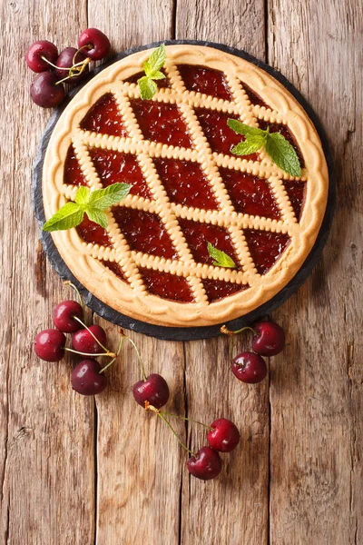 Вкусный открытый вишневый пирог Crostata крупным планом на столе. Вертикаль — стоковое фото
