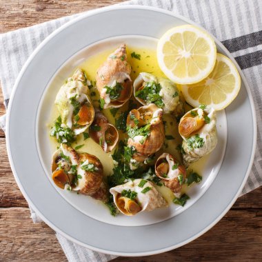 Tereyağı, sarımsak ve maydanoz, limon yakın çekim masada bir soslu tarifi Whelks Fransız. abov üzerinden üstten görünüm