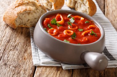 Ev yapımı İtalyan yemeği domates sosu ile baharat kalamar ve maydanoz yakın çekim bir pot ve taze ekmek kızarmış. Horizonta