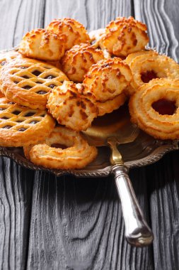 Lezzetli altın kurabiye bisküvi siyah bir tabloda bir tabakta yakın çekim ayarlayın. dikey, rustik styl