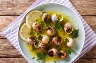 Yenilebilir salyangoz, bir tablo bir tabağa tereyağı, otlar ve sarımsak yakın çekim ile escalgot. Abov gelen dikey üstten görünüm