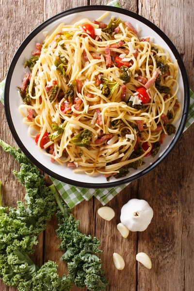 Italienisches Mittagessen mit Pasta mit Grünkohl, Speck, Tomaten und Pa — Stockfoto