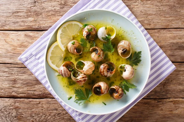 烹调的法国蜗牛 Escalgot 与黄油 柠檬和大蒜特写在桌子上的盘子 Abov 的水平顶部视图 — 图库照片