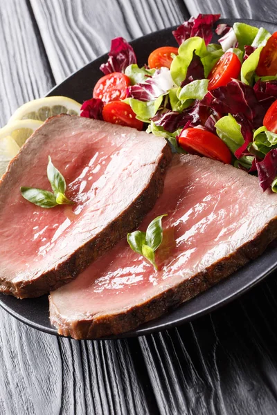 Steak de boeuf rare fraîchement cuit avec salade de légumes frais à proximité - — Photo