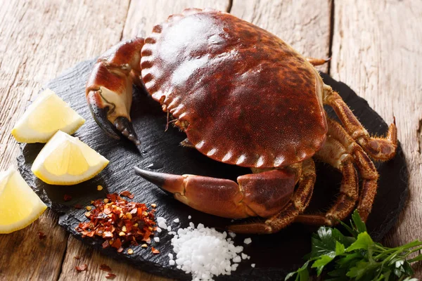 fresh Brown Crab (Cancer Pagarus) with spices for cooking close-up on the table. horizonta