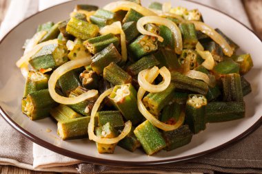 Asya mutfağı: yeşil bamya kızarmış soğan yakın masada bir plaka üzerinde çekim ile. Horizonta