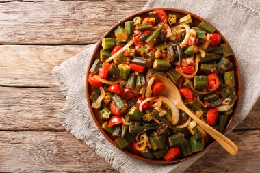 Bir tabloda bir tabakta domates ve soğan yakın çekim ile taze hazırlanmış bamya. abov üzerinden yatay üstten görünüm