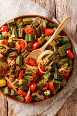 Domates ve soğan yakın çekim masaya bir tabak kızarmış bamya. Abov gelen dikey üstten görünüm