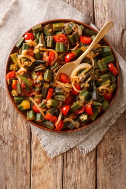 Bir tabloda bir tabakta domates ve soğan yakın çekim ile taze hazırlanmış bamya. Abov gelen dikey üstten görünüm