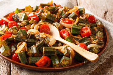 Bamya domates ve soğan yakın masada bir plaka üzerinde çekim ile pişmiş güveç. Horizonta