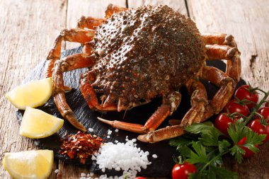Ham örümcek yengeç domates, limon ve otlar ile ahşap bir arka plan üzerine kapatın. Horizonta