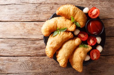 Kızarmış panzerotti domates, otlar ve mozzarella yakın çekim bir kara tahta üzerinde bir dolgulu. Abov üzerinden yatay üstten görünüm