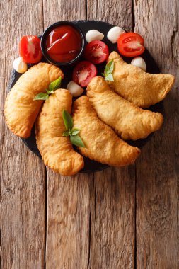Kızarmış panzerotti domates, otlar ve mozzarella yakın çekim bir kara tahta üzerinde bir dolgulu. Abov gelen dikey üstten görünüm