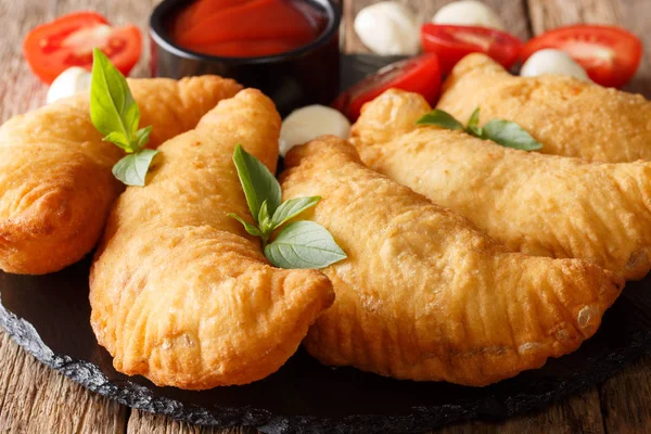 İtalyan Lokanta: domates sos, otlar ve mozzarella yakın çekim bir kara tahta üzerinde ile kızarmış panzerotti. Yatay Rusti'yi