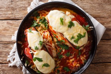 İhale tavuk göğsü patlıcan dilimleri, jambon, makarna sosu, mozzarella peyniri ve Parmesan yakın bir tabloda bir plaka üzerinde çekim ile tepesinde. Abov üzerinden yatay üstten görünüm