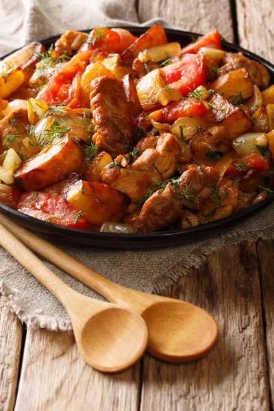 Porco frito com batatas, tomates e temperos close-up em um frite — Fotografia de Stock