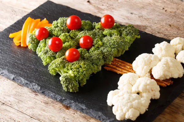 Christmas tree of broccoli, cauliflower, tomato, pepper closeup on table. Vegetarian menu. horizonta