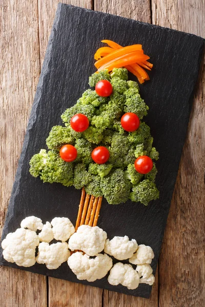 Christmas tree of broccoli, cauliflower, tomato, pepper closeup