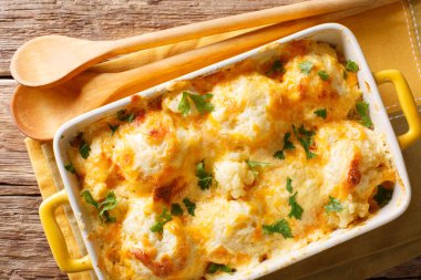 Güveç bir pişirme çanağı bir tablo içinde peynir sosu yakın çekim ile karnabahar üzerinden. Abov üzerinden yatay üstten görünüm