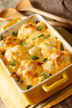 Fırında karnabahar çedar peyniri ve bir pişirme çanağı içinde krem yakın çekim. Vertica