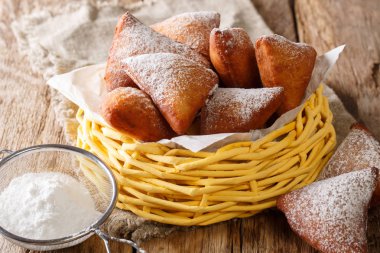 Lezzetli donuts Doğu Afrika Mandazi masada bir sepet içinde pudra şekeri yakın çekim ile kızartılmış. Horizonta