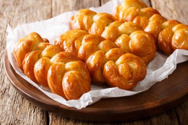 Güney Afrika Koeksisters taze hazırlanmış derin yağda kızartılmış, yapışkan çörek batırılmış limon şurubu yakın çekim masaya bir tabak içinde. Horizonta