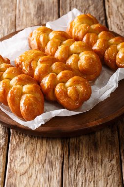 Geleneksel Koeksisters Güney Afrikalı yapışkan çörek tatlı, yapışkan, gevrek ve sırılsıklam şurup, masaya bir tabak tarçın, limon ve zencefil yakın çekim ile bağcıklı. Vertica