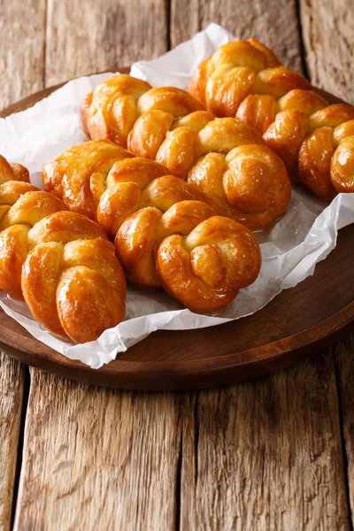 Geleneksel Koeksisters Güney Afrikalı yapışkan çörek tatlı, yapışkan, gevrek ve sırılsıklam şurup, masaya bir tabak tarçın, limon ve zencefil yakın çekim ile bağcıklı. Vertica