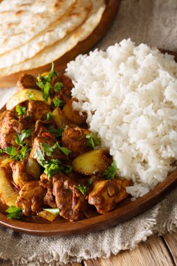 Lezzetli Hint tavuk soğan ve bir tabak pirinç yakın çekim gözleme bir tablo ile garnitür ile pyaza (dopiaza) yapmak. Vertica