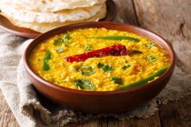 Baharat, ot ve masanın üzerine bir kase chili biber yakın çekim ile sarı mercimek tarifi lezzetli Dal Tadka. Horizonta